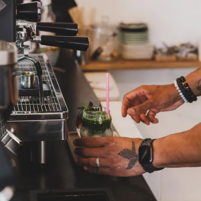 Barista preparing an iced matcha latte